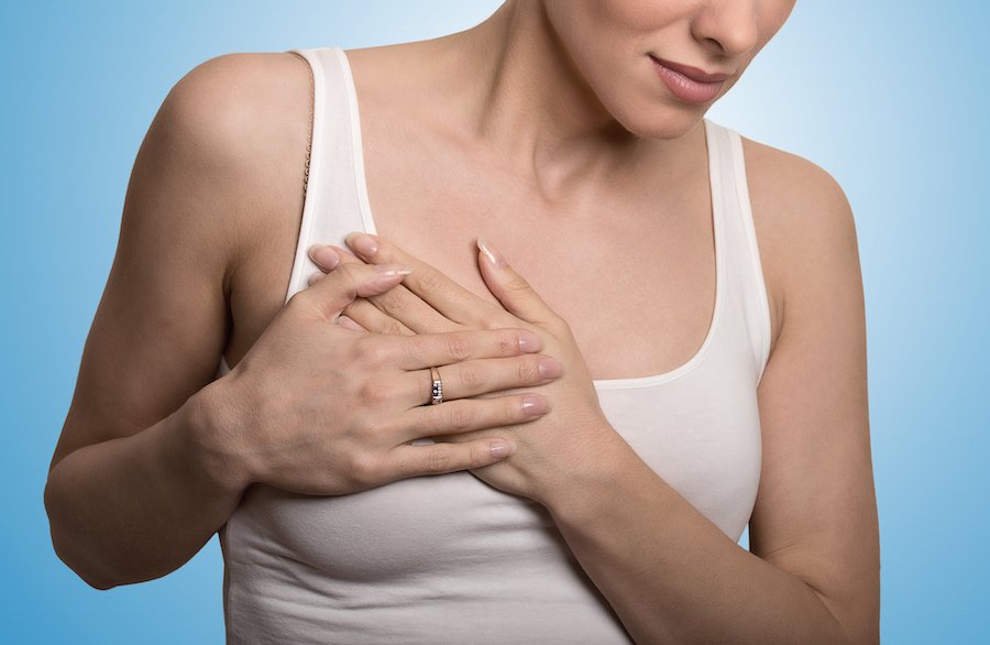 Woman clasping her chest in pain