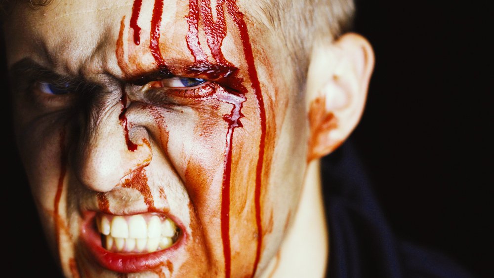man with angry expression and blood on his face