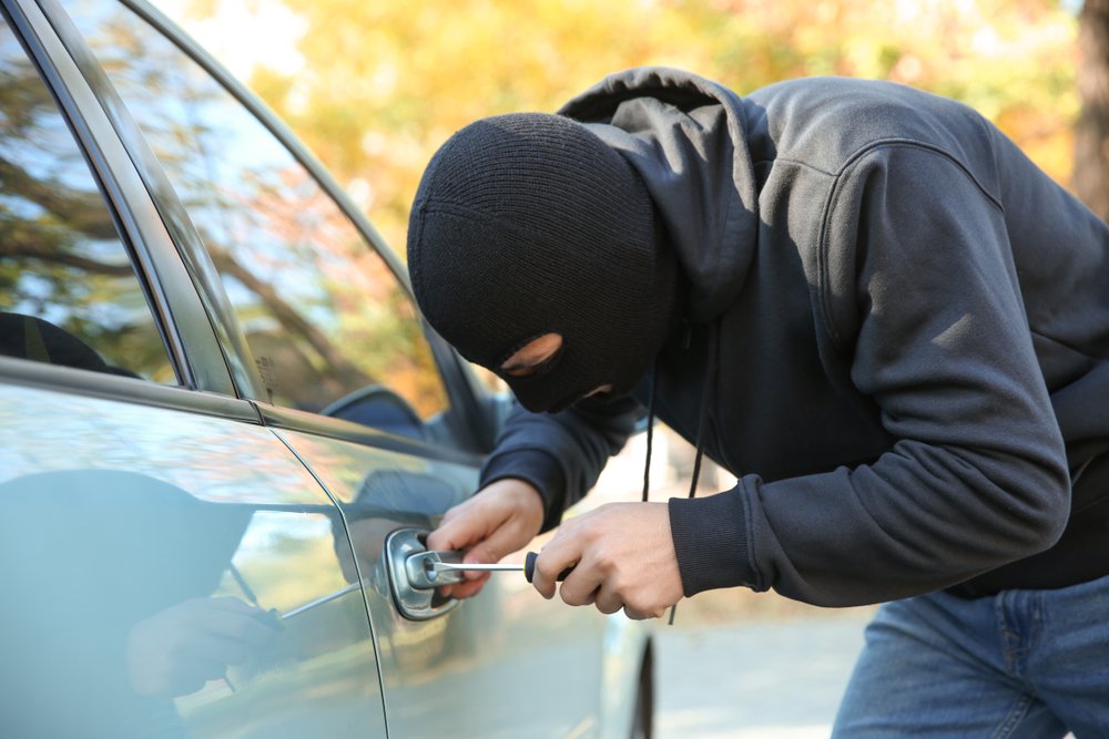 ladrón intentando romper un coche