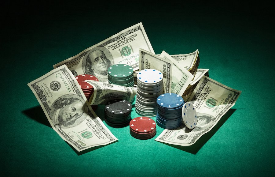 Poker chips and dollar Money bills on green cloth