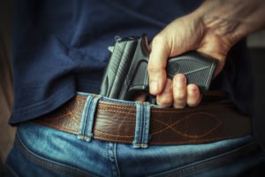 Man tucking gun into jeans