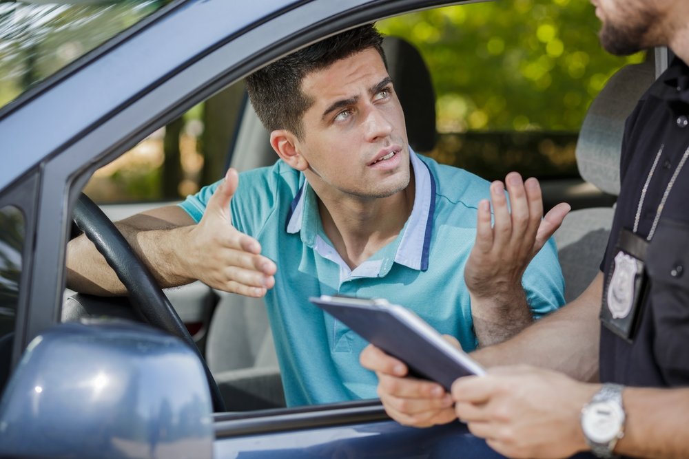 Un oficial emitiendo una multa de tráfico a un motorista: una violación de CVC 5204 puede resultar en una multa