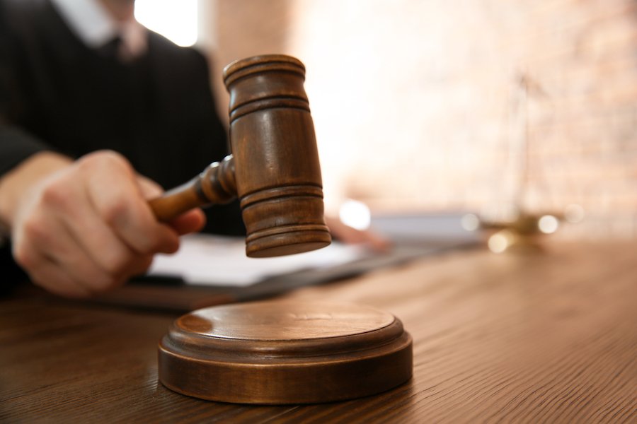 Judge hammering a gavel in a courtroom during a trial