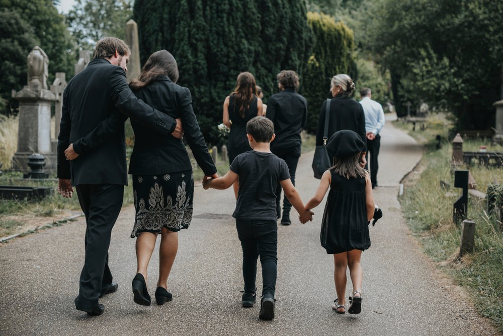 A grieving family walking after a funeral.