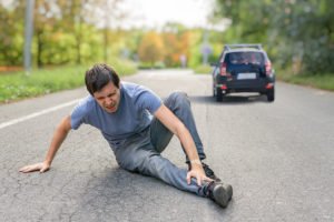 Man on road after being hit by car driving away