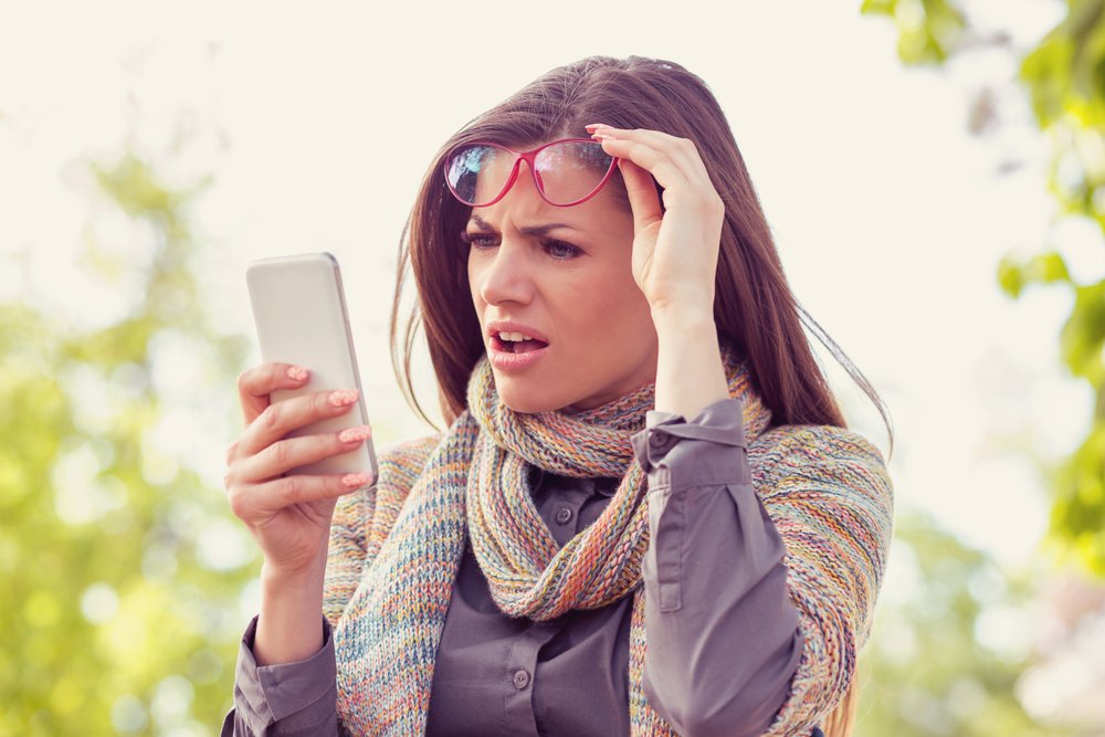 Mujer sorprendida por lo que está leyendo en su teléfono inteligente.