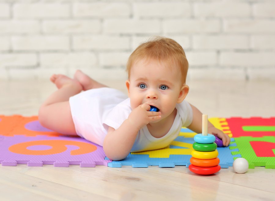 Baby putting small toy in mouth