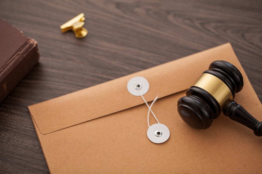 gavel and large envelope on desk