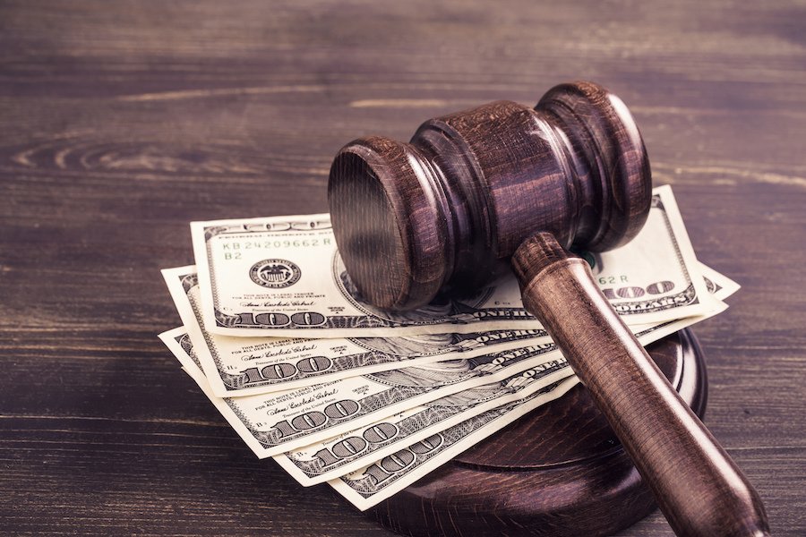 $100 billetes bajo un martillo de juez - el Programa de Compensación para Víctimas de California puede ayudar a las víctimas de delitos a obtener compensación financiera