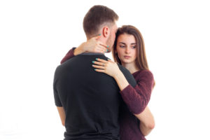 An older man holding a young woman against a white background, exhibiting a bit of an age difference.