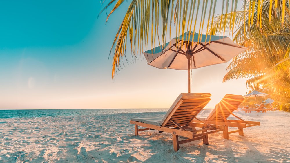 Two unused sun chairs in a tropical location.