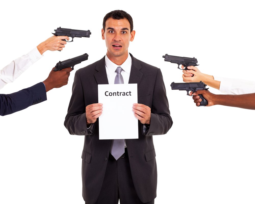 Hombre sosteniendo un contrato mientras múltiples armas apuntan hacia él.