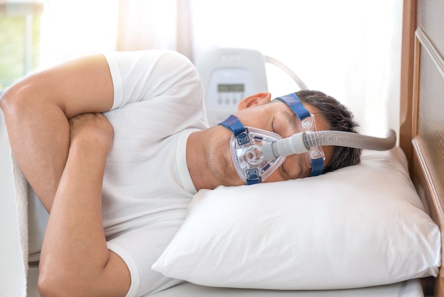 Patient sleeping with CPAP mask - current lawsuits allege the device can cause lung problems and cancer