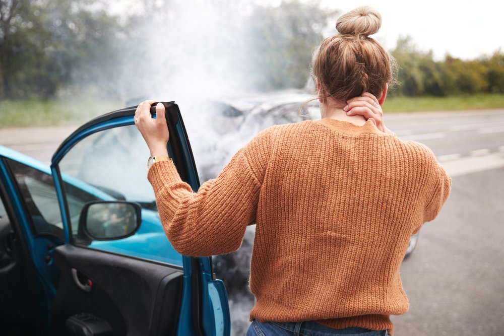 Female driver holding her neck after a head-on collision.