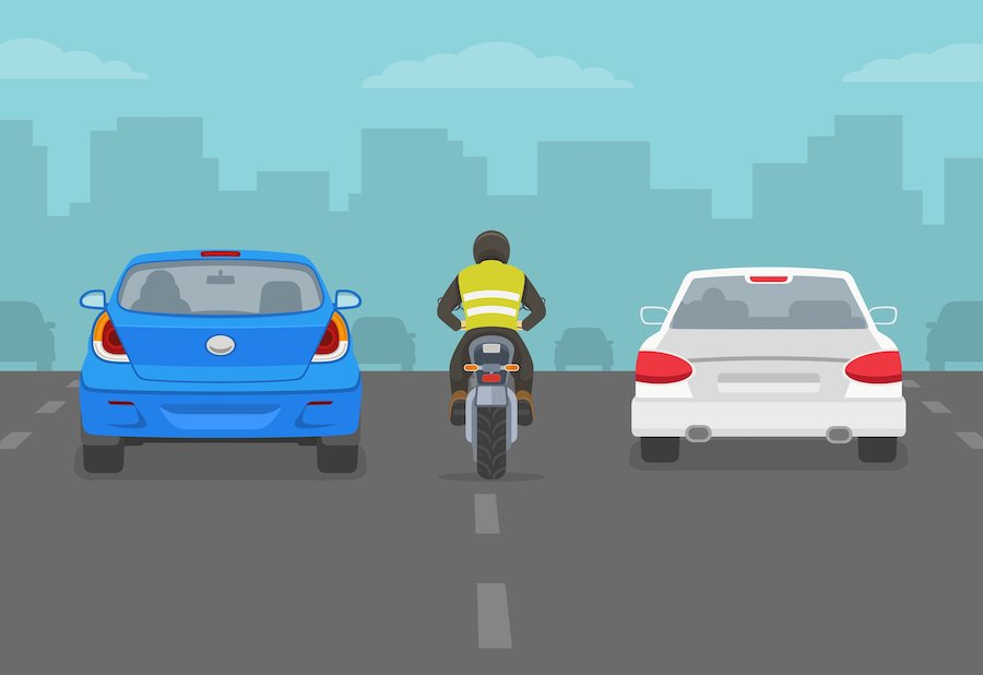 Motociclista entre autos en carretera de la ciudad o autopista Motociclista entre autos en carretera de la ciudad o autopista