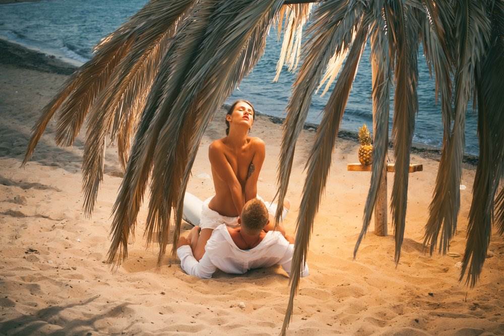 A couple sharing intimacy on the beach.