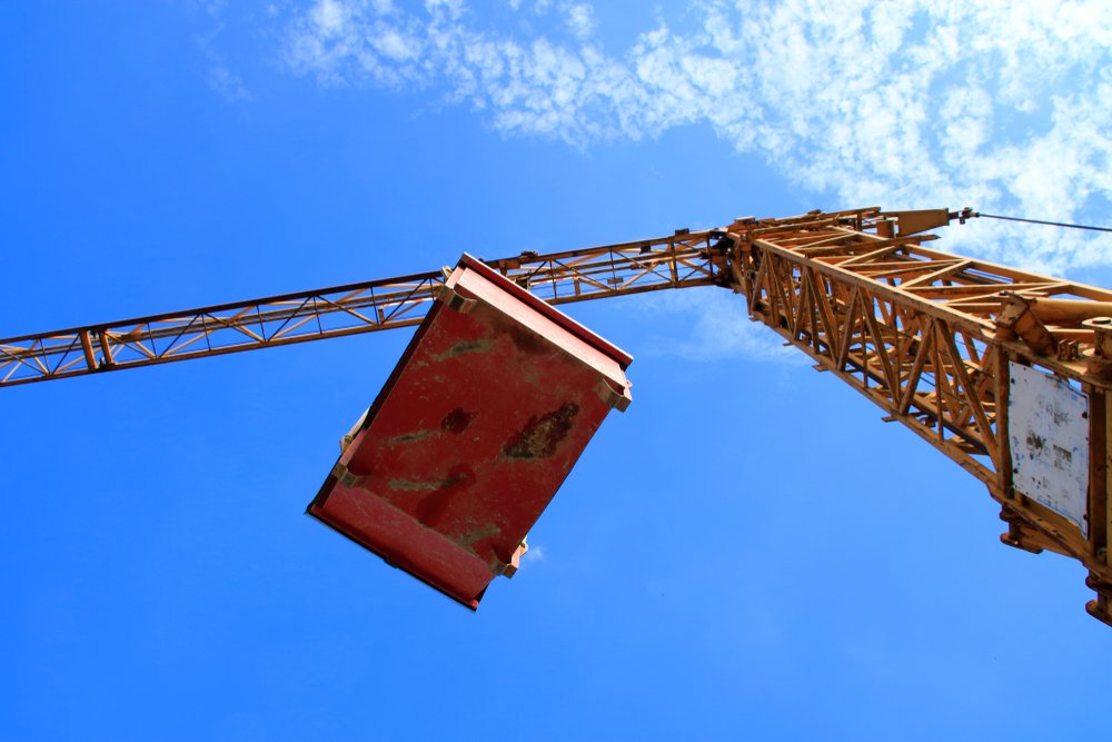 View of crane carrying load against the sky