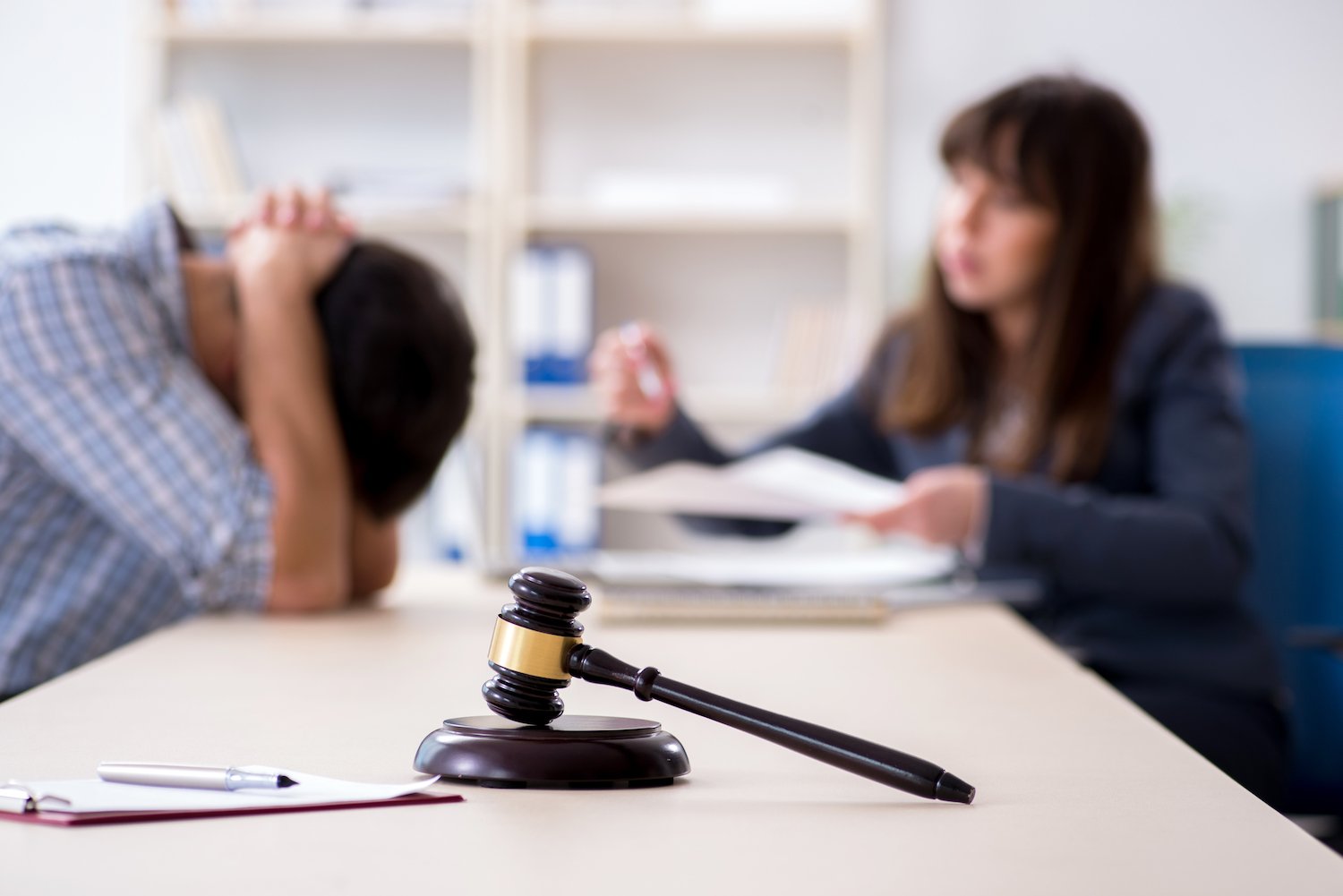 Attorney speaking with a client at her office with a gavel in the foreground