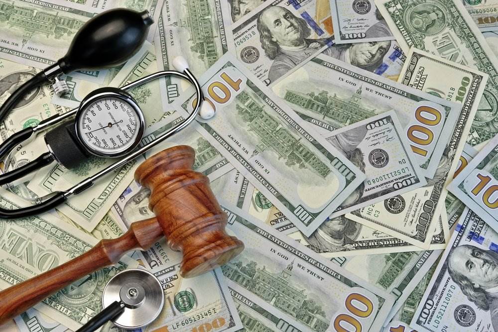 Money, a gavel, and doctor's stethoscope to illustrate health care fraud