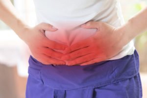 Hernia mesh patient holding stomach in pain after mesh rejection