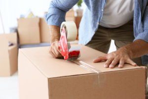 Person on probation packing a moving box