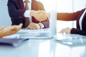 Two attorneys shaking hands after a negotiation