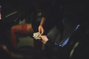 A prostitute being handed money.