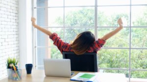 Mujer en el escritorio estirándose durante un descanso del trabajo