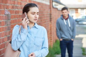 Mujer en teléfono celular siendo hablada por hombre en la calle