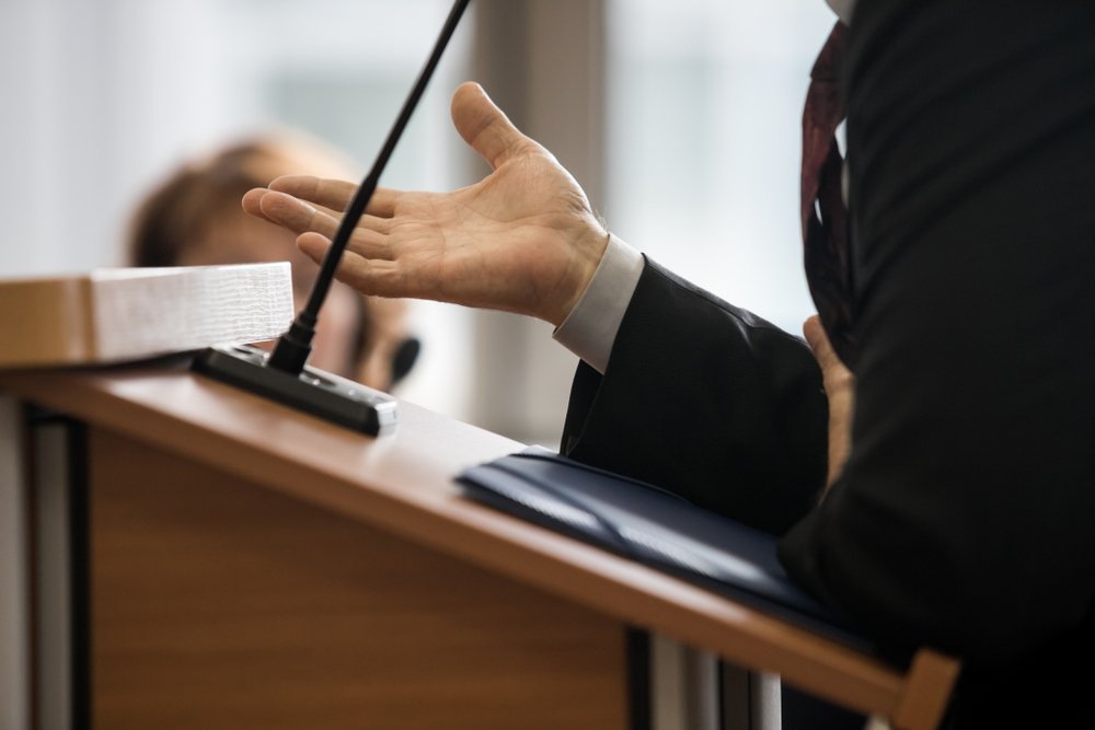 Abogado hablando desde un atril - la preponderancia de la prueba es el estándar de prueba en la mayoría de los juicios civiles