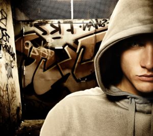 Teenager in front of graffiti.