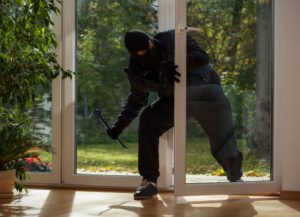 A burglar breaking into a house.