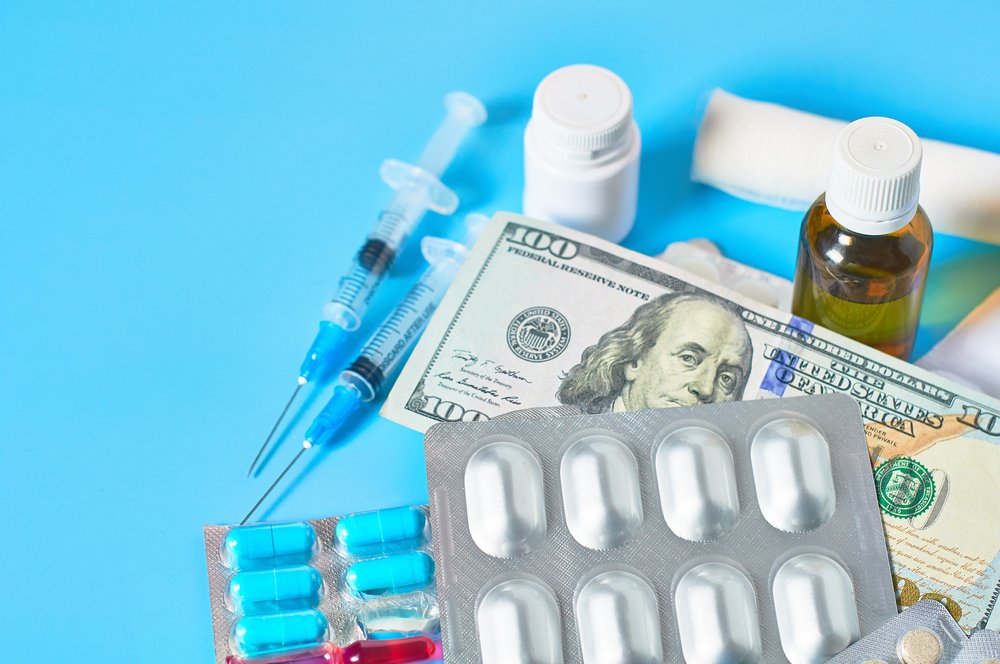 Varios medicamentos y pastillas en una mesa junto a dinero.