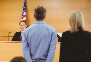 Defendant standing next to attorney in front of judge in court as judge grants a stay of adjudication