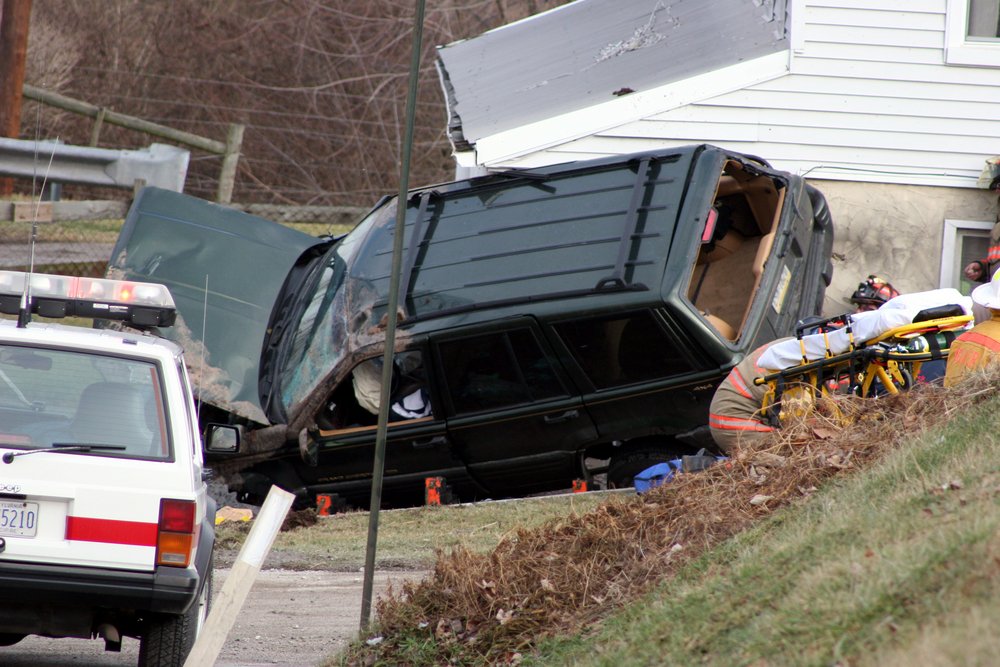 An SUV being tended to by emergency workers after a rollover accident