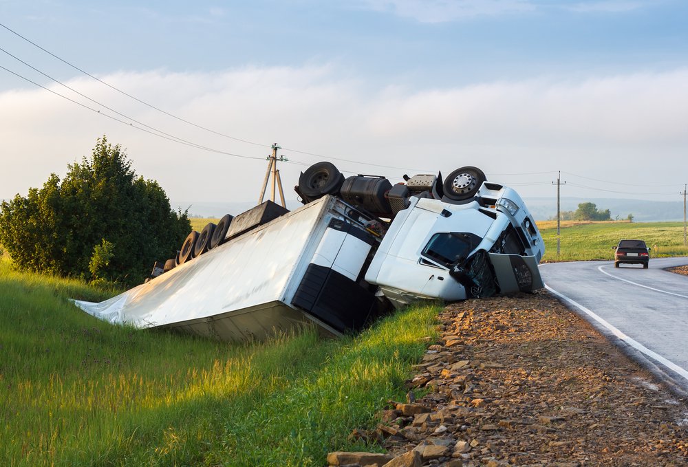 18 wheeler flipped on the side of a highway.