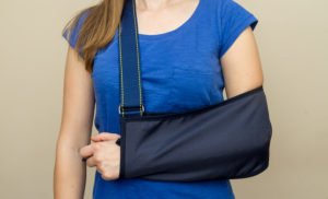 Woman with a broken arm in a sling, which is a serious bodily injury under CRS 18-1-901