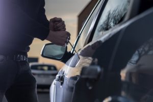 Ladrón rompiendo en el coche para robarlo en violación de CRS 18-4-409
