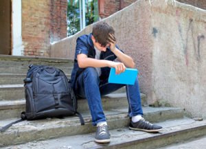 Distraught teen boy after being suspended pursuant to EC 48900.