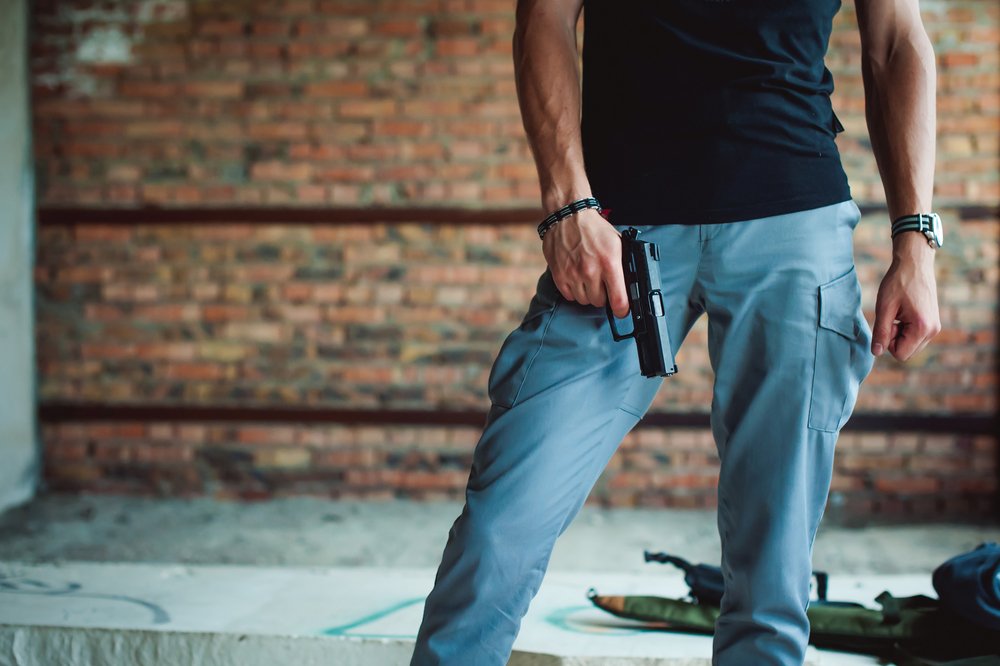A man holding a pistol by his waist.