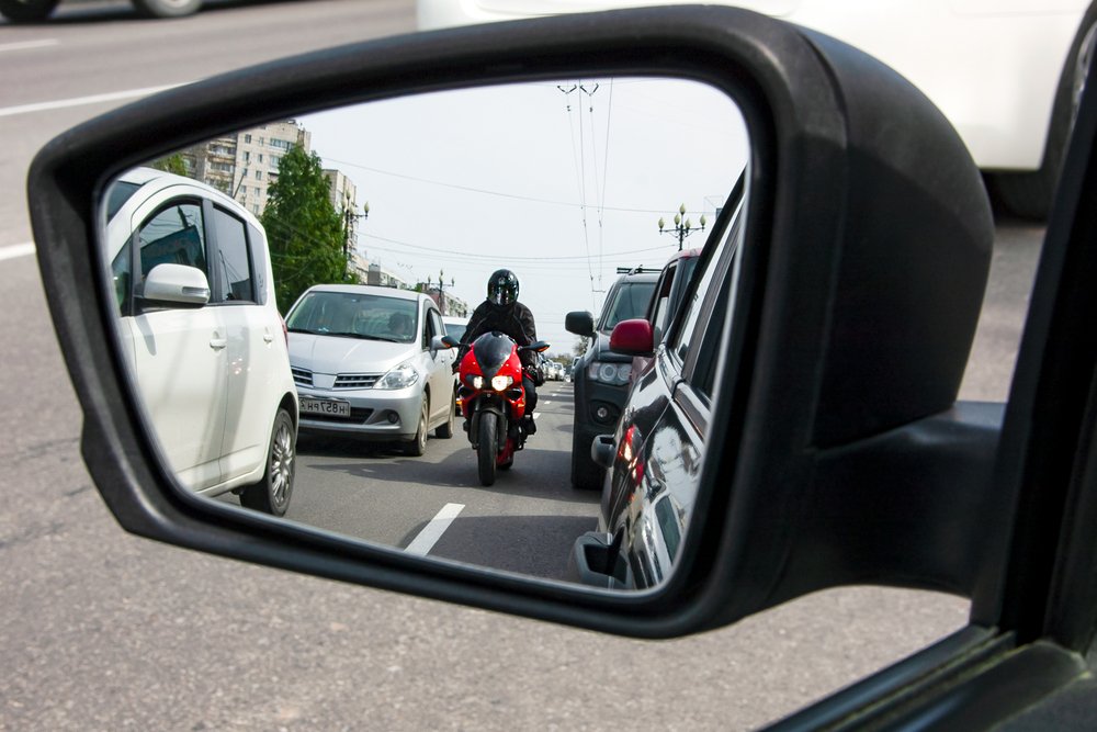 Una motocicleta dividiendo carriles - el lane splitting está permitido bajo la ley de California