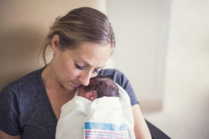Mother cradling baby in NICU