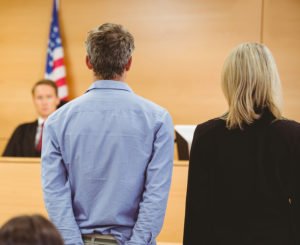 Juez en la sala de audiencias sentenciando al acusado parado junto a su abogado a libertad condicional de acuerdo con NRS 176A.500