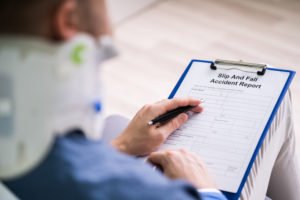 Injured man filling out slip and fall accident report.