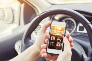 Closeup of driver looking up car insurance rates on smart phone following a DUI