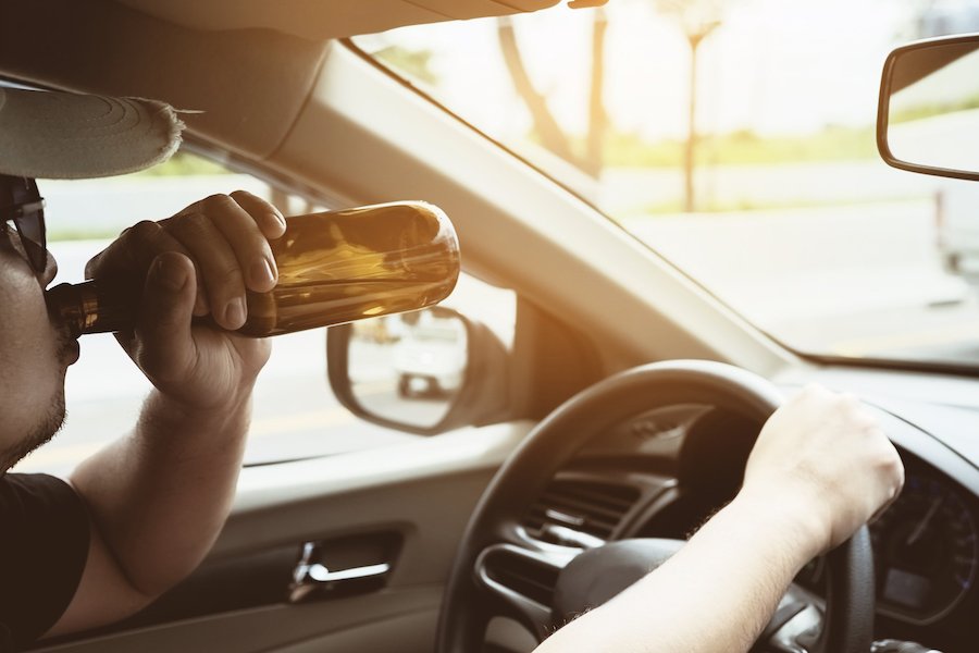 Driver with beer behind wheel