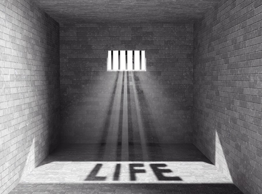 Prison cell with shadows of bars spelling out "LIFE"