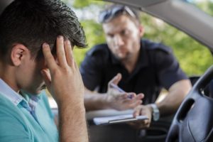Un oficial de policía hablando con un sospechoso detenido por conducir bajo la influencia de drogas