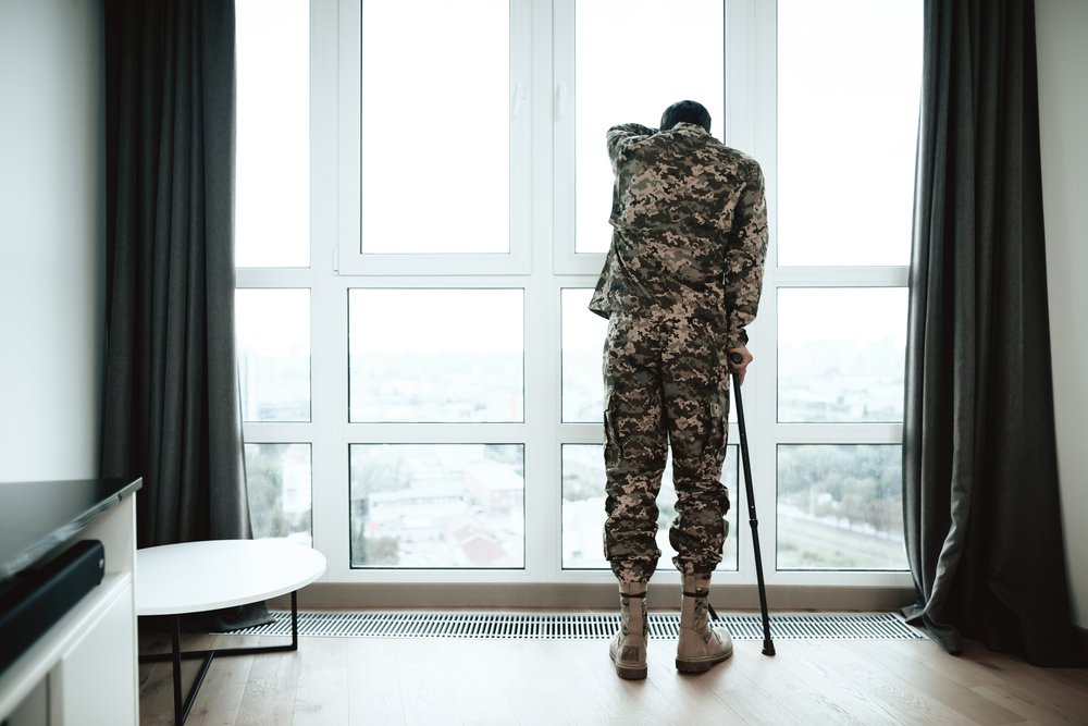 An injured servicemember holding a cane.