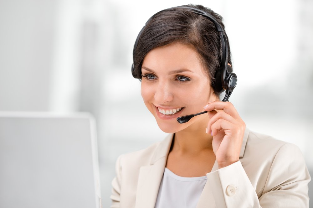 Female receptionist assisting over the phone.